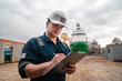 © Igor Kardasov - Marine Deck Officer or Chief mate on deck of offshore vessel or ship doing check and filling checklist. Paperwork at sea. Ship is on background