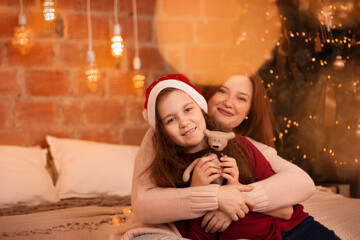 Happy mother hugs her 8 years daughter and looking at camera