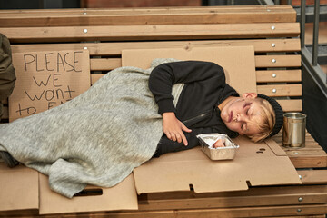 Wall Mural - boy isbegging food and shelter on streets in the cold weather, wearing dirty clothes. child abuse.