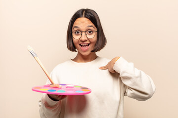 Canvas Print - young hispanic woman looking happy, proud and surprised, cheerfully pointing to self, feeling confident and lofty