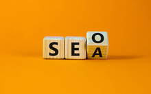 SEO Vs SEA. Turned A Cube And Changed The Word 'SEA - Search Engine Advertising' To 'SEO - Search Engine Optimization'. Business And SEO Or SEA Concept. Beautiful Orange Background, Copy Space.