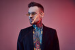 © Fxquadro - Portrait of a positive and stylish male hipster person with tattooed body and fashionable hairstyle in black jacket