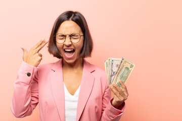 Wall Mural - young hispanic woman looking unhappy and stressed, suicide gesture making gun sign with hand, pointing to head