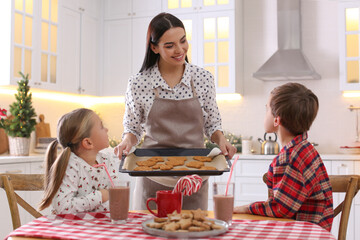 Sticker - Mother giving her cute little children freshly baked Christmas cookies in kitchen