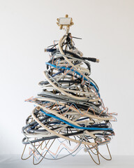 A geeky Christmas tree made of coax cables, telephone cords, and a splitter on a white background.