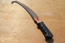 Old Pruning Saw On Wooden Flooring For Cutting And Sculpting The Branches Of Trees.