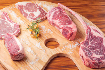 Wall Mural - Premium cuts of raw steak. Fresh and raw meat. Raw meat mixture. Raw steaks on wooden table.