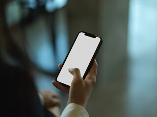 Female hand using smartphone in blurred background