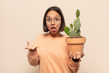 young latin woman feeling extremely shocked and surprised, anxious and panicking, with a stressed and horrified look