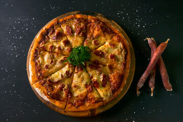 top view Traditional crispy Italian pizza with cheese and chistorras black rustic wooden background. hot pizza.