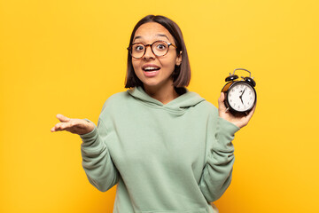 young latin woman feeling extremely shocked and surprised, anxious and panicking, with a stressed and horrified look