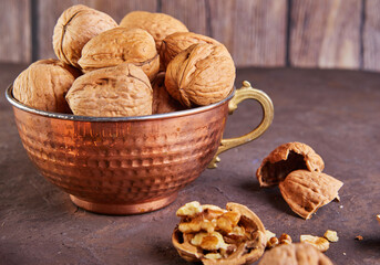 Poster - Walnuts in a tin cup, whole and finely chopped, next to the filling and shell. Home storage of winter preparations