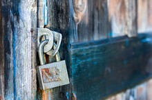 Old Metal Lock On The Door Of A Wooden House. Close Up.