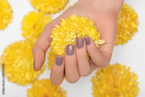 Leinwand Poster Female hand with glitter beige nail design