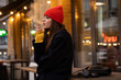 © Drobot Dean - Charming caucasian girl in hat smoking while standing at city street