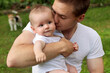 © marigo - A young guy holds a baby boy in his arms and shows a gentle and warm relationship.