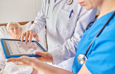 Wall Mural - medicine, healthcare and people concept - doctors with table pc computer and senior woman at hospital