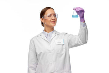 science, chemistry and people concept - happy smiling young female scientist in goggles with chemical in flask making test or research