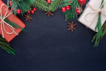 Top view above of Christmas holiday background. Composition with fir pine branches, Gift kraft box decorations on black background. Winter, Christmas, new year concept. Flat lay, copy space.