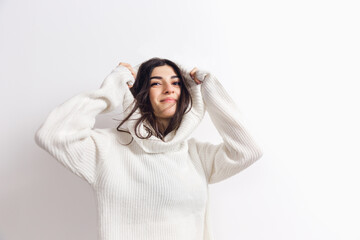 Happiness. Portrait of beautiful brunette woman in comfortable soft longsleeve isolated on white studio background. Home comfort, emotions, facial expression, winter mood concept. Copyspace.