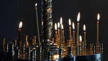 Thin Candles Burning In Church Candle Holder