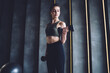 © BullRun - Serious caucasian female in active wear using dumbbells for lifting weight and training arms standing in gym strong woman satisfied with workout using equipment reaching fitness goals for slimming