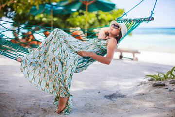 Wall Mural - Adorable girl on tropical vacation relaxing in hammock