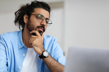 Wall Mural - Closeup Portrait Of Focused Handsome Arab Guy In Eyeglasses Working On Laptop