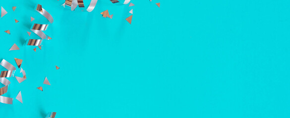Wall Mural - close up on group of silver color of rolling ribbon and confetti on teal background with copy space 
