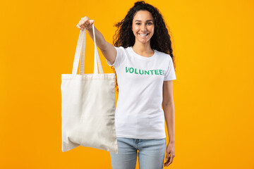 Wall Mural - Volunteer Lady Showing White Eco Bag Standing Over Yellow Background