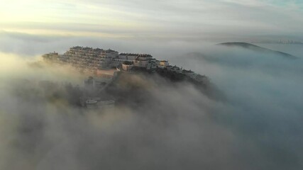 Wall Mural - Aerial drone point of view La Manga del Mar Menor hillside coastal neighbourhood residential buildings during misty weather in early morning, Mediterranean Seascape, cloudy sky. Murcia, southern Spain