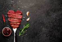 Different Degrees Of Roasting Beef Steak In Heart Shape With Spices On A Meat Fork On A Stone Background With A Copy Of The Space For Your Text