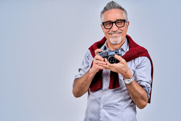 Happy handsome adult man holding retro camera in studio