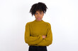 © Jihan - Picture of angry Young beautiful African American woman wearing knitted sweater against white wall looking camera.