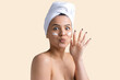 © Mountains Hunter - Beauty portrait of woman in white towel on head applies cream to the face. Skincare cleansing eco organic cosmetic spa relax concept.