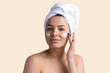 © Mountains Hunter - Beauty portrait of woman in white towel on head applies cream to the face. Skincare cleansing eco organic cosmetic spa relax concept.