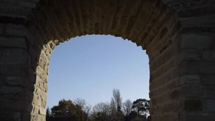 Wall Mural - Sandal Castle ruins archway against blue sky and tree background medium shot