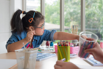 Group of young Asian disabled child complex genetic disorders girls draw a picture with watercolor together in element classroom