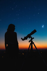 Wall Mural - woman looking at night sky with amateur astronomical telescope.