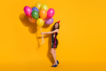 Wall Mural - Full length photo of positive girl hold many balloons enjoy festive luxury occasion wear short mini glossy chic skirt isolated over bright shine color background