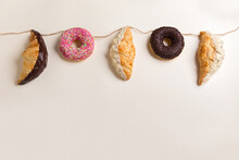 
Garland Of Croissants And Donuts On A Light Background