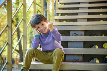 Happy boy talking excited with opened mouth on smartphone. Outdoor. Technology, winning, people, children concept