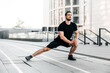 © Ivan - Runner doing side lunges. Portrait of sporty man doing stretching exercises before training. Male athlete preparing for jogging outdoors. Sport active lifestyle concept. Full length.