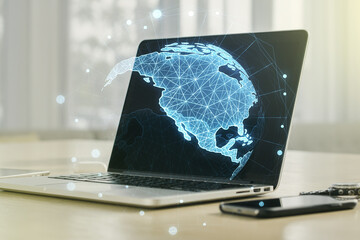 Digital America map on modern laptop background, international trading concept. Multiexposure