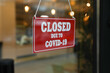 © New Africa - Red sign with words 'Closed Due To Covid-19' hanging on glass door