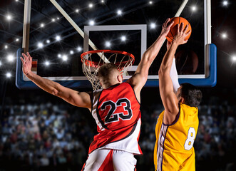 Two basketball players in arena. Blocked shot