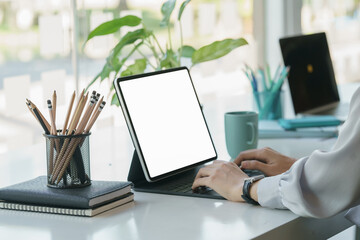 Leinwandbilder - Side view of businesswoman working on a digital tablet, mug, and schedule book on counter bar.	