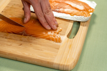 Poster - Selective focus shot of a cook cutting fish on a cutting board for sushi