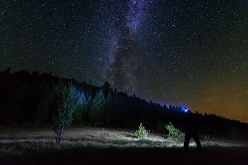 Wall Mural - fantastic starry night with galaxy milky way with a tourist and a tent on the mountain range in the 