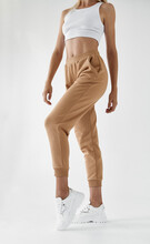 Fit Woman Standing In Light Beige Pants And White Shirt